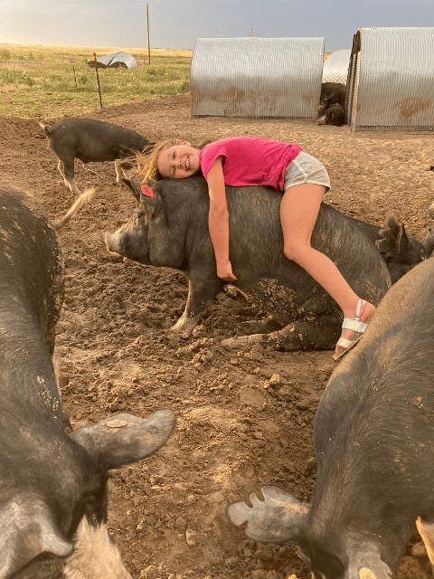 Girl Hugging a Pig